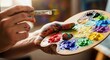 © Ирина Батюк - Vibrant pigments decorate a wooden palette while a skilled creator's messy hands dip a brush, fostering boundless creative expression and colorful inspiration.