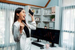© InfiniteFlow - Successful wealthy with extremely smiling in young Asian businesswoman earning high profit raising fist up with standing jump, holding smartphone in exchange stock market at modern office. Stratagem.