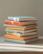 © Lairi Art - Stack of hardcover books with pastel-colored covers on a light surface. Soft daylight, smooth paper edges, simple vertical arrangement, and large plain background