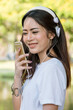 © aFotostock - Vertical Horizon Happy asian woman use headphones listen to music from smartphone outdoor travel on vacation. Vertical Music mental therapist for relax woman. Leisure cheerful wellness woman smile