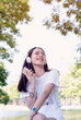 © aFotostock - Vertical Horizon Happy asian woman use headphones listen to music from smartphone outdoor travel on vacation. Vertical Music mental therapist for relax woman. Leisure cheerful wellness woman smile