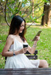 © aFotostock - Vertical Horizon Woman drinking coffee hands holding hot disposable cup in green park. Vertical Happy Relax beautiful asian woman smiling face standing outdoors garden. Women enjoy nature Lifestyle