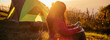 © aFotostock - Banner Women camping outdoor sitting Tent Camp trip hiking mountain hill on sunrise. Panorama Tent camp nature background flare sunlight mountain. Picnic green Adventure Travel forest with copy space