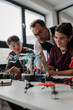 © Halfpoint - High school students working on robotics project with their teacher.