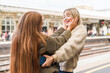 © Iryna - Two friends greeting each other at a train station in the afternoon sun