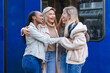© Iryna - Friends share a happy moment together near a public transport station in the city during the day