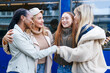 © Iryna - Friends greet each other while standing near a blue bus on a sunny day in the city