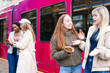 © Iryna - Two girls talk at a train station while two others use their phones nearby