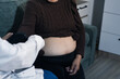 © Aungkana - cropped shot of doctor examining pregnant woman during medical consultation