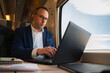 © Cristian Blázquez - Businessman working on laptop during a train commute