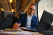 © Cristian Blázquez - Business man working on laptop during train journey