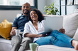 © nenetus - Cute couple using computer while lying on the couch at home.