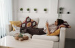 © Friends Stock - Woman Lying Comfortably On Sofa, Serene Lady Reclined On Couch While Scrolling Through Her Device