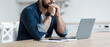 © Prostock-studio - Upset, sad, depression, frustrated and work at home. Concentrated pensive millennial bearded male looks at laptop and pressed hands to mouth, sits at table in kitchen interior, profile, panorama