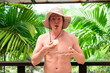 © Ranta Images - Scandinavian Tourist Man Eating Durian Outdoors with Tropical Leaves Background