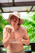 © Ranta Images - Scandinavian Tourist Man Eating Durian Outdoors with Tropical Leaves Background