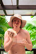 © Ranta Images - Scandinavian Tourist Man Eating Durian Outdoors with Tropical Leaves Background