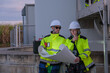 © Freeday photo - Two wind turbine technicians inspect blueprints at wind farm in the evening