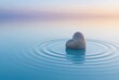 © DreamStock - Smooth heart shaped stone resting on calm water surface with ripples at sunset rock pebble