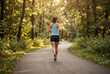 © Abdelati - Female runner running at summer park trail . Healthy fitness woman jogging outdoors.