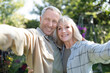 © Prostock-studio - Happy senior spouses making selfie, hugging, smiling to camera, spending time together in their garden outdoors. Retirement lifestyle, marriage and family moments