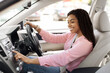 © Prostock-studio - Road Playlist. Side View Profile Portrait Of Happy Black Woman Driving Car And Listening To Music On Auto Audio System, Checking Automobile Options During Test Drive Pushing Button On Turning On Radio