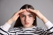 © New Africa - Amnesia. Woman trying to remember something on grey background