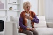 © New Africa - Heart attack. Senior woman suffering from pain in chest indoors