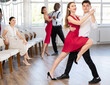 © JackF - Energy man and girl are dancing tango in couple during lesson at studio. Leisure activities and physical activity for positive people.