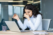 © Liubomir - Stressed young woman working at office desk and rubbing eyes from headache, feeling tired and burned out, experiencing pressure and eye strain from computer work
