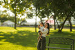 © Wasana - Asian mother holding baby enjoying sunny park day