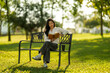 © Wasana - Young woman enjoying book reading in park nature