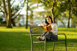 © Wasana - Young woman enjoying quiet reading time in park