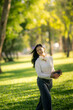 © Wasana - Young woman walking in park enjoying nature