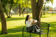 © Wasana - Woman relaxing on park bench checking smartphone