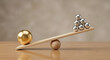 © solom - large gold sphere balancing on wooden seesaw against group of small silver spheres for business leadership competition quality over quantity and market advantage concept