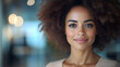 © Hanna - Woman smiles in an office setting during the day with soft lighting and a modern environment