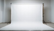 © gunara - Empty indoor photo studio with a seamless white backdrop and professional lighting equipment, ready for a photoshoot
