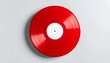 © bento - Red vinyl record with white label resting on a light gray surface.