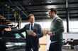 © Drazen - Happy salesman talking to his customer who is looking for a new vehicle at car dealership.