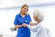© Graphicroyalty - Kind female doctor in blue scrubs holding the hand of a senior woman patient to offer support and comfort during a medical consultation in a bright clinic office for compassionate care