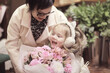 © kichigin19 - A girl and her grandmother choose and buy a bouquet of flowers at a flower shop, an autumn or spring holiday greeting
