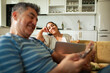 © Marko Geber - Happy couple relaxing with wine and devices at home