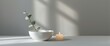© The 2R Artificiality - White bowl holding eucalyptus left branch alongside a burning candle, gray interior, minimalist still life with selective soft focus, horizontal background of light and shadow nature
