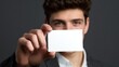 © InfiniteStudio - Young man holds blank card as he prepares to write a message for someone special in indoor space during daytime