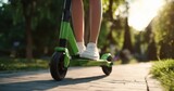 The Electric Scooter Close-Up on a Sunlit Park Path with Casual Rider