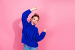 © deagreez - Young woman in blue knit sweater celebrating with a joyful pose against pink background