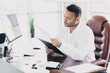 © deagreez - Busy young businessman reviews documents at a stylish office desk with charts