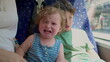 © Marco - Crying toddler sitting on bus seat next to older sibling, visible distress and emotional reaction during public transport ride in daylight