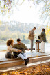 © BGStock72 - Friends gather by the lake for music and laughter on a sunny autumn day